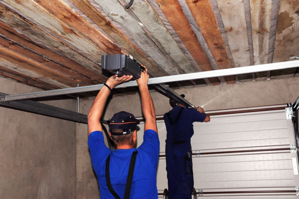 Contractors installing garage door opener.